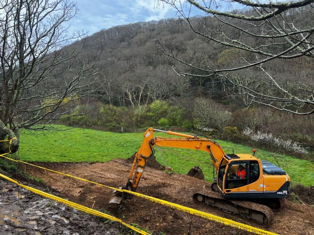 Excavator at work on a rural groundwork site