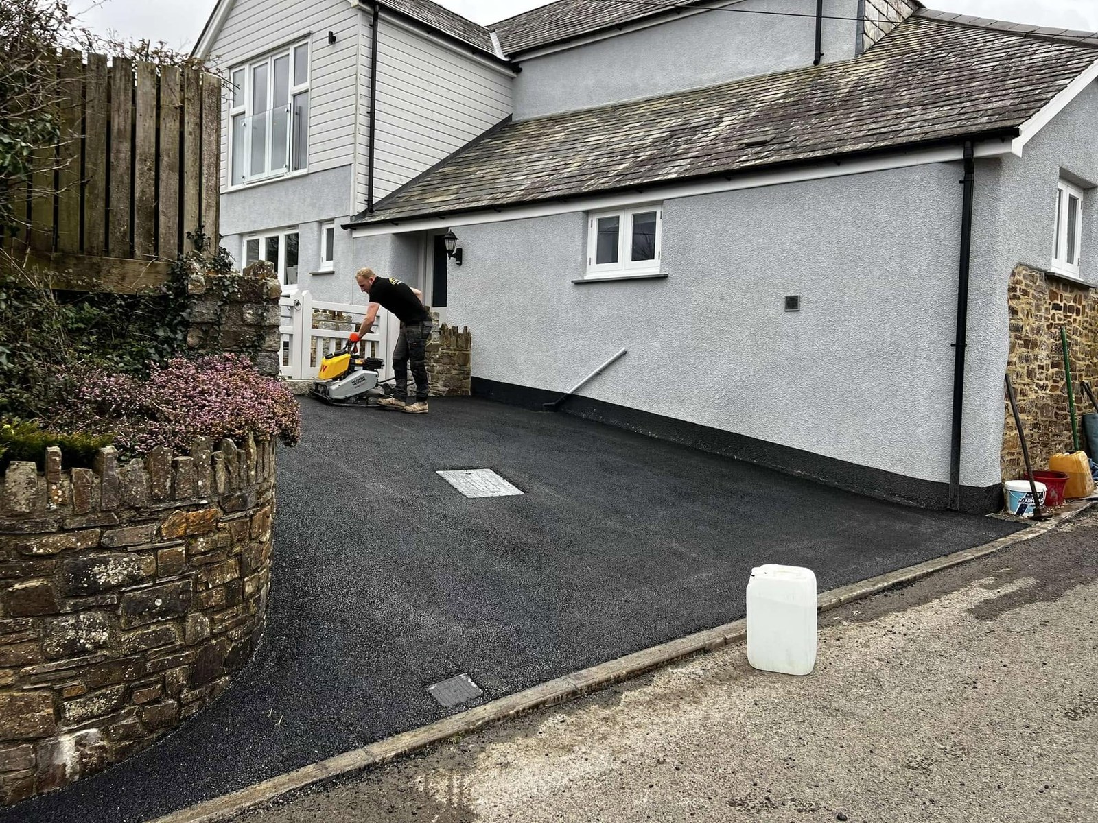 Finished surfaced driveway beside a white cottage