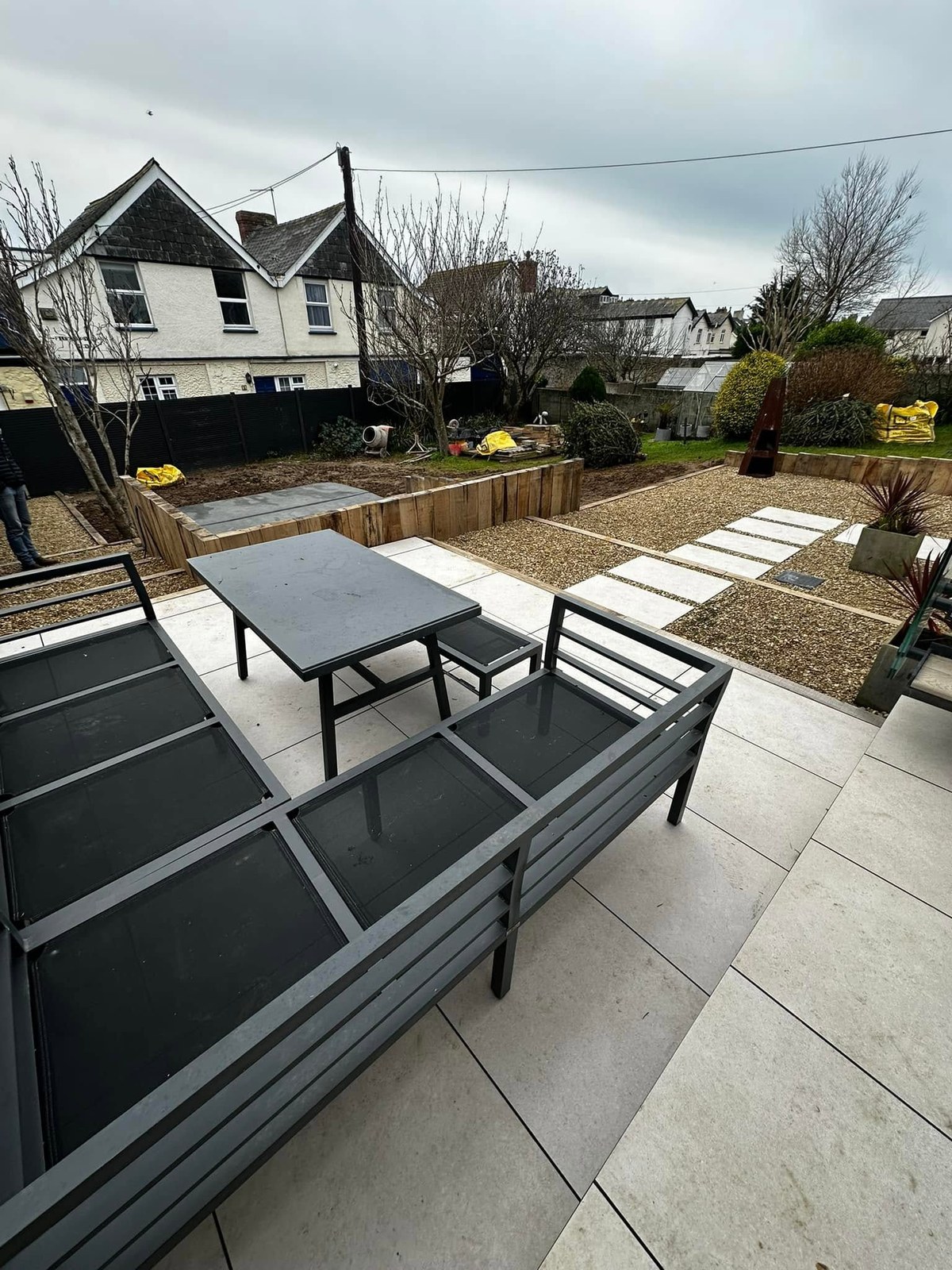 Paved garden seating area with steps and landscaped borders