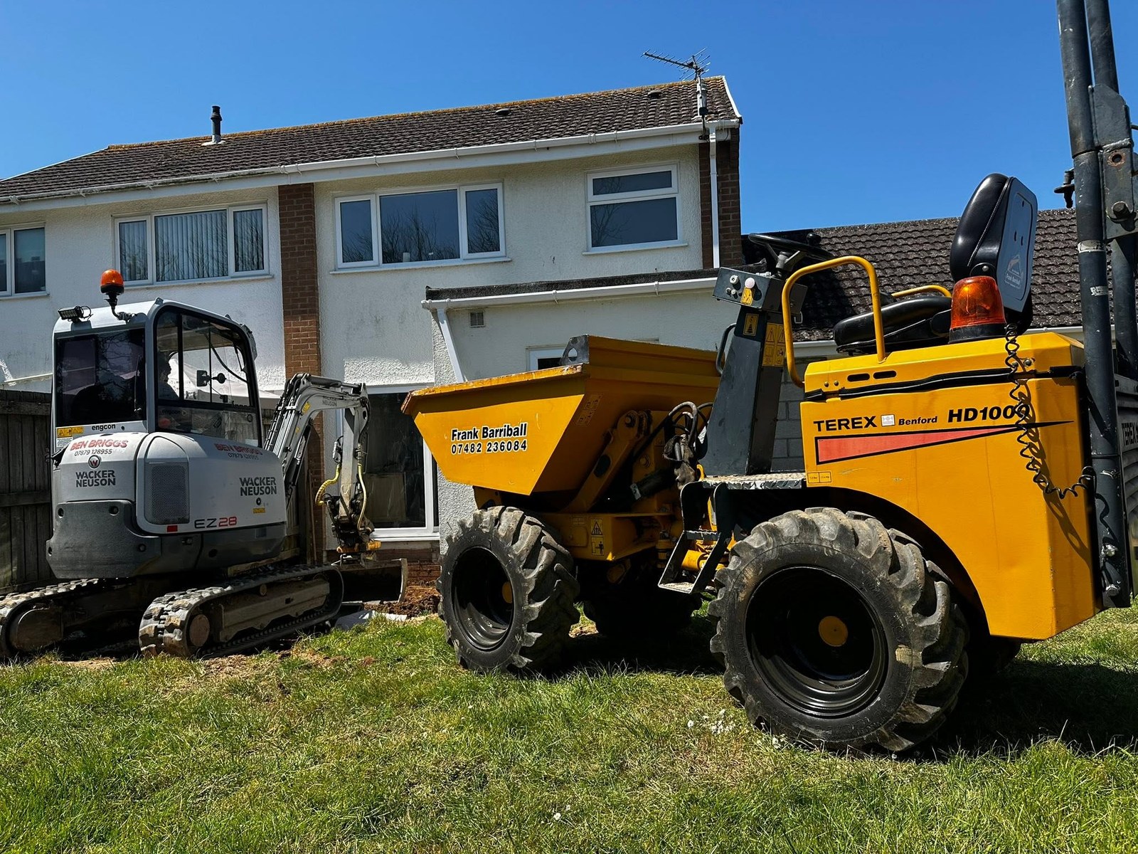 Yellow site dumper parked beside a residential property