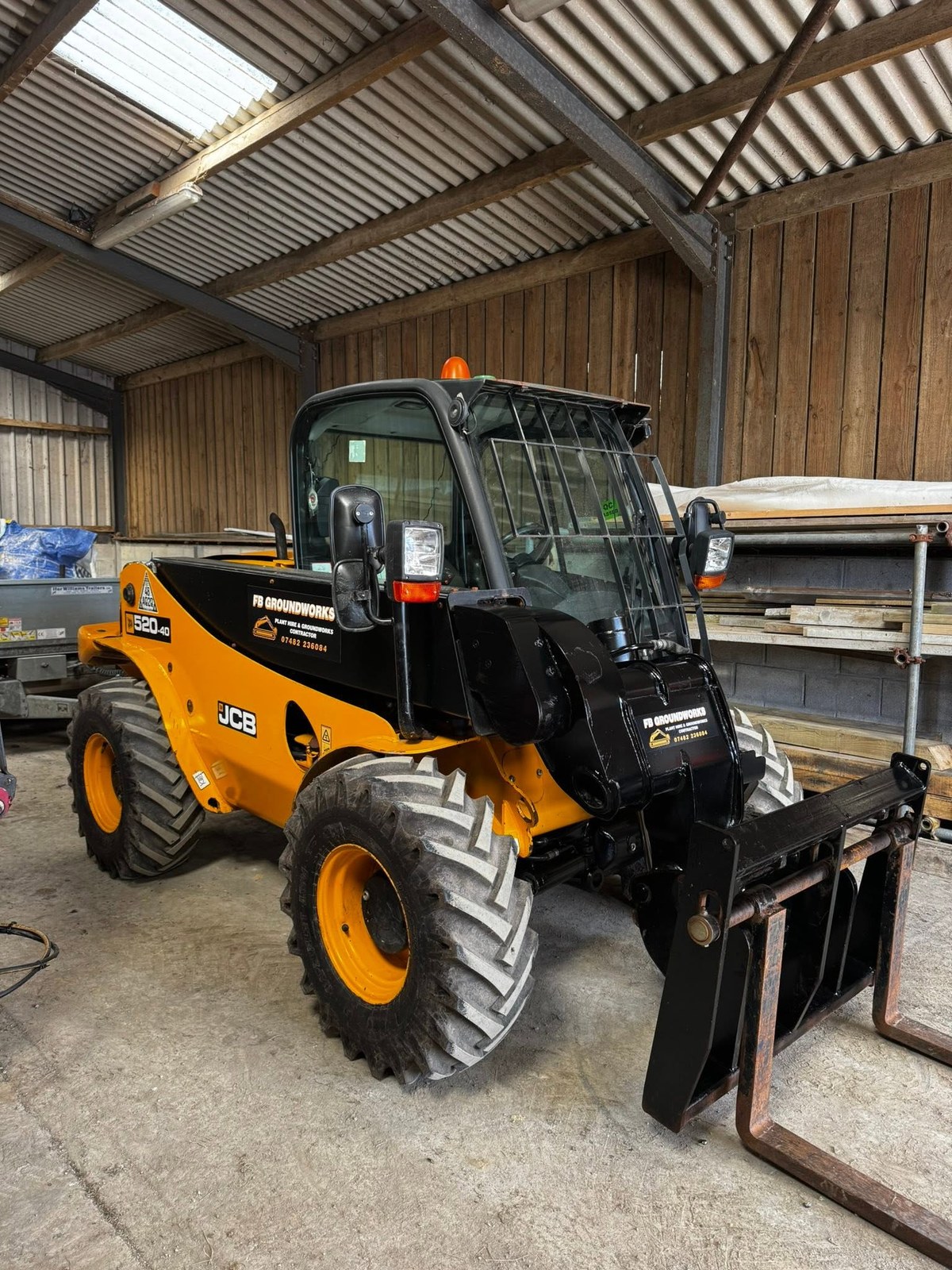 Yellow telehandler parked inside a workshop